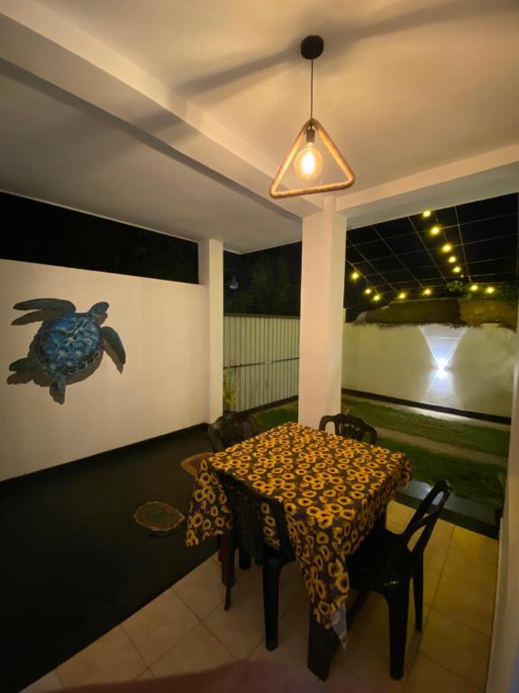 a dining room with a table and a bird on the wall at BE MY Guest in Mirissa