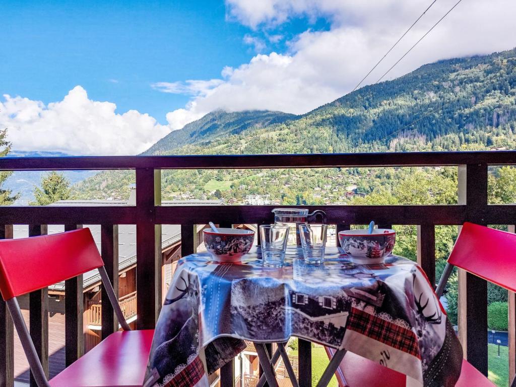 - une table avec des verres à vin sur un balcon avec des montagnes dans l'établissement Studio La Piste-5 by Interhome, à Saint-Gervais-les-Bains