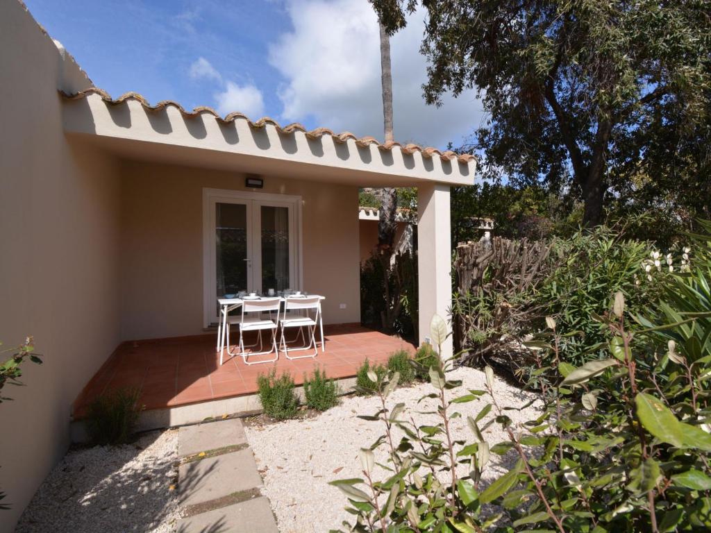 una piccola casa con un tavolo e sedie su un portico di Holiday Home Mirto Marino-3 by Interhome a Costa Rei