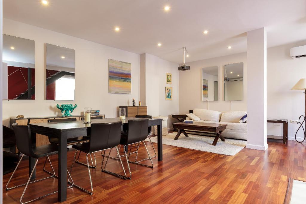 a dining room and living room with a table and chairs at Dream Vacation at Casa Vicki in Almería