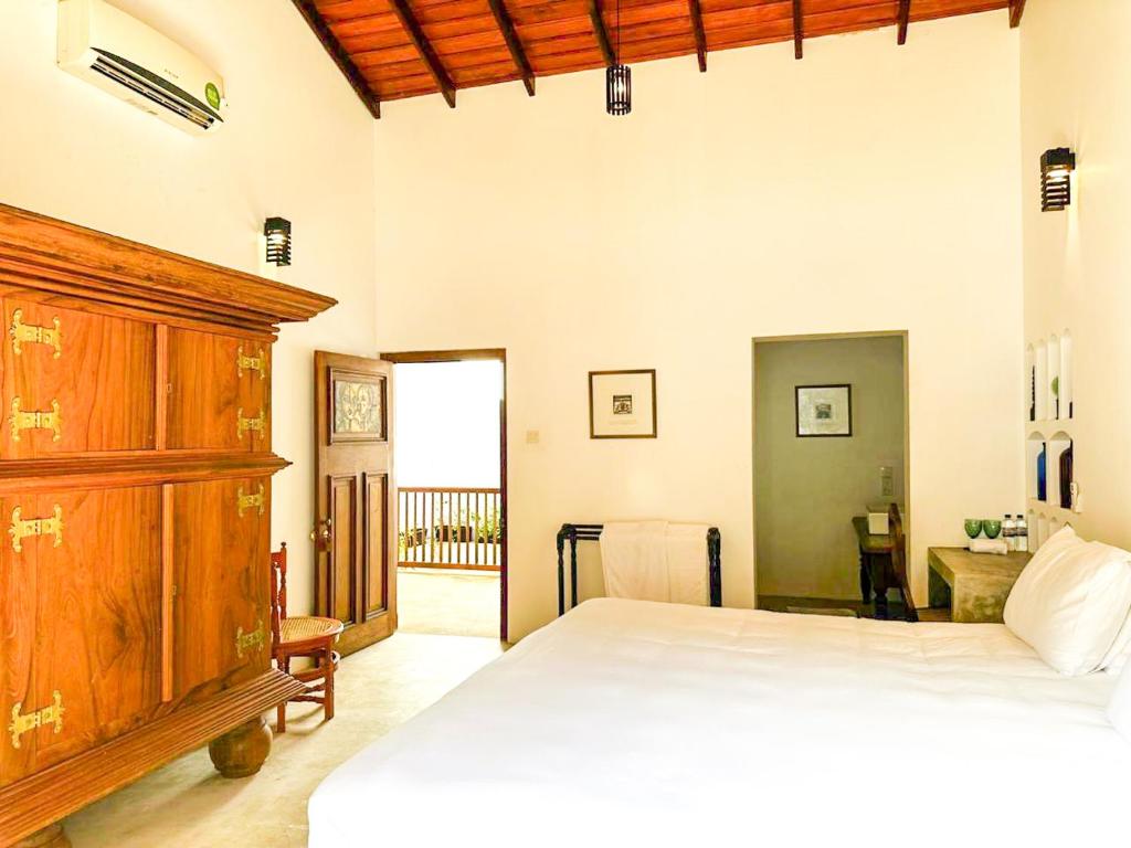 a bedroom with a bed and a wooden cabinet at Pt de Galle in China Garden