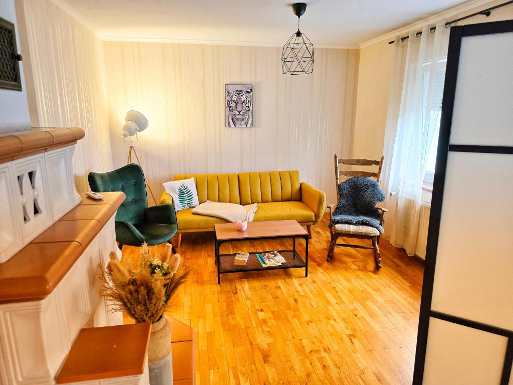 a living room with a yellow couch and chairs at Ferienwohnungen Lindenhof in Falkenberg
