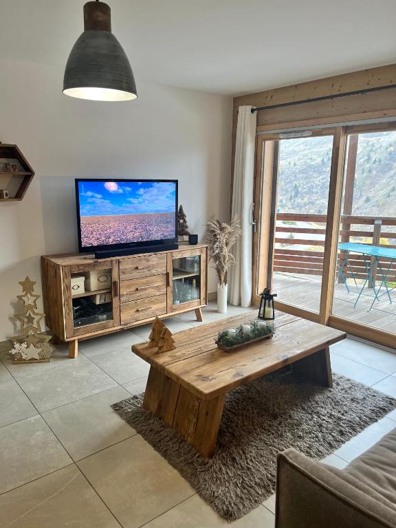 un salon avec une télévision et une table basse dans l'établissement Appartement 6 personnes au cœur de Valmeinier - Céleste 102, à Valmeinier