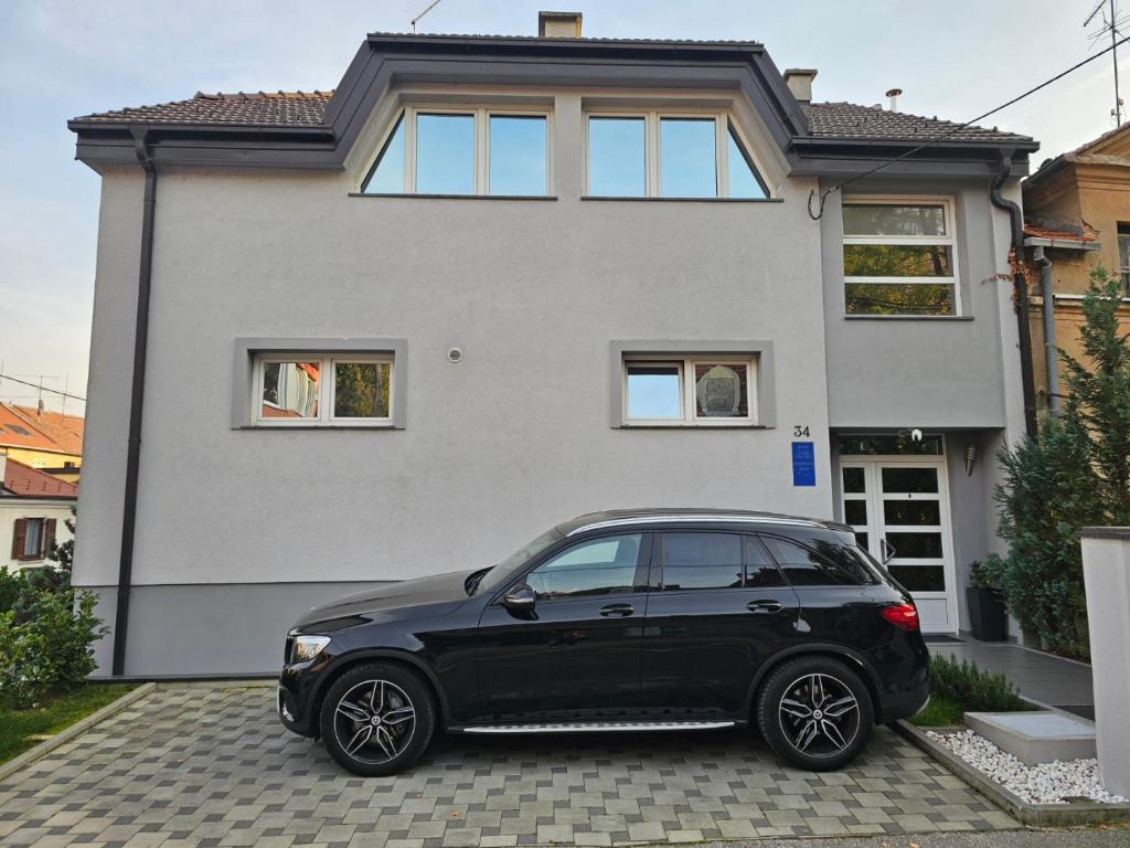 Czarny samochód zaparkowany przed domem w obiekcie Apartments Battistutti - Free Private Parking w Zagrzebiu