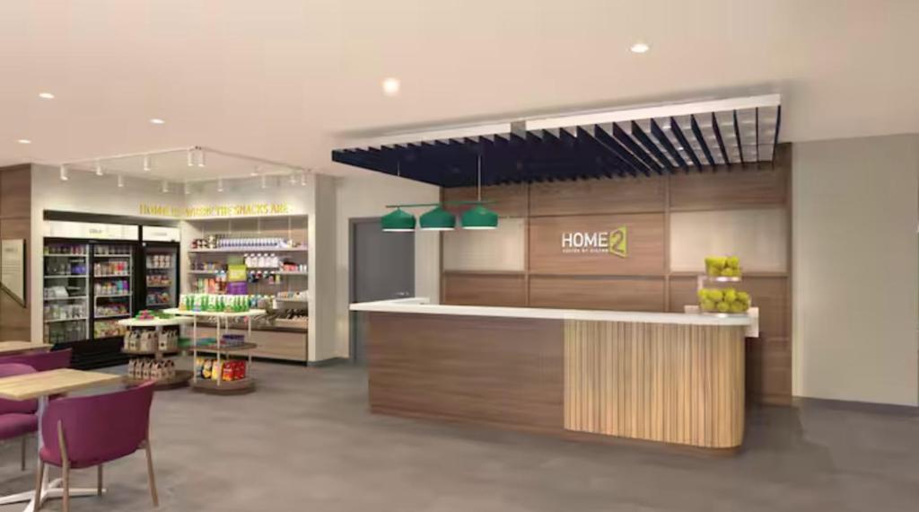 哈里森堡Home2 Suites By Hilton Harrisonburg University的一间杂货店,配有柜台和紫色椅子