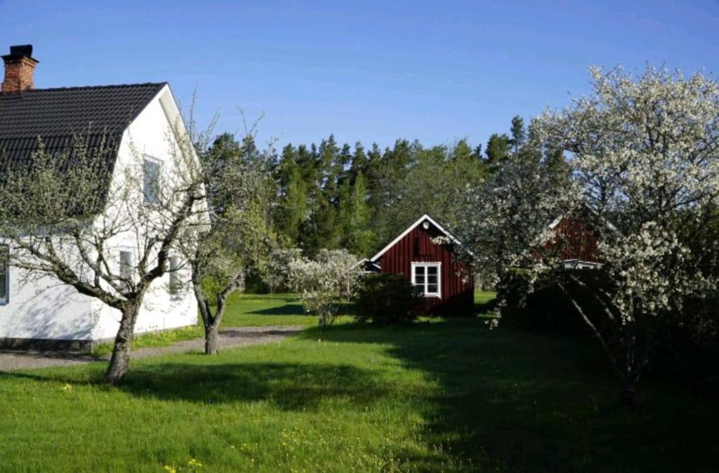 a house and a red and white house and trees at Emil Hemma in Järnforsen