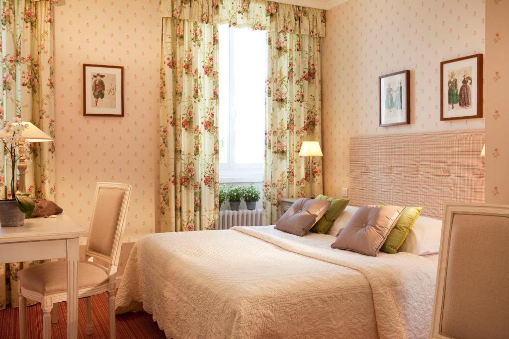 1 dormitorio con cama, escritorio y ventana en Gradlon, en Quimper