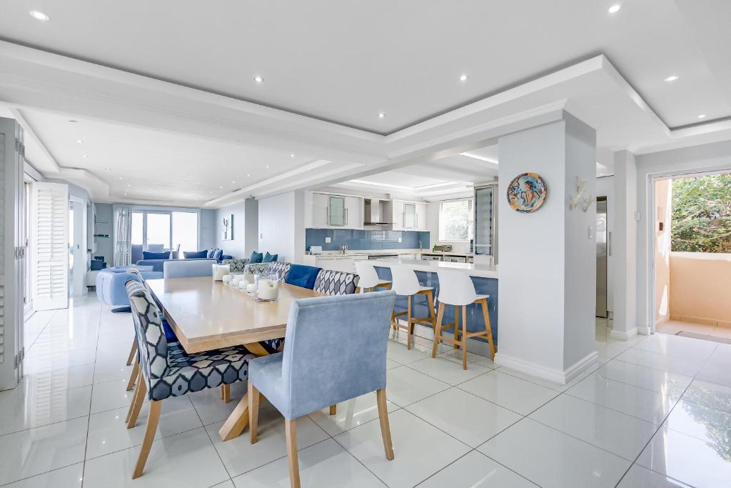 a dining room and kitchen with a table and chairs at 122 Camarque-Lavish lookout Penthouse in Umdloti