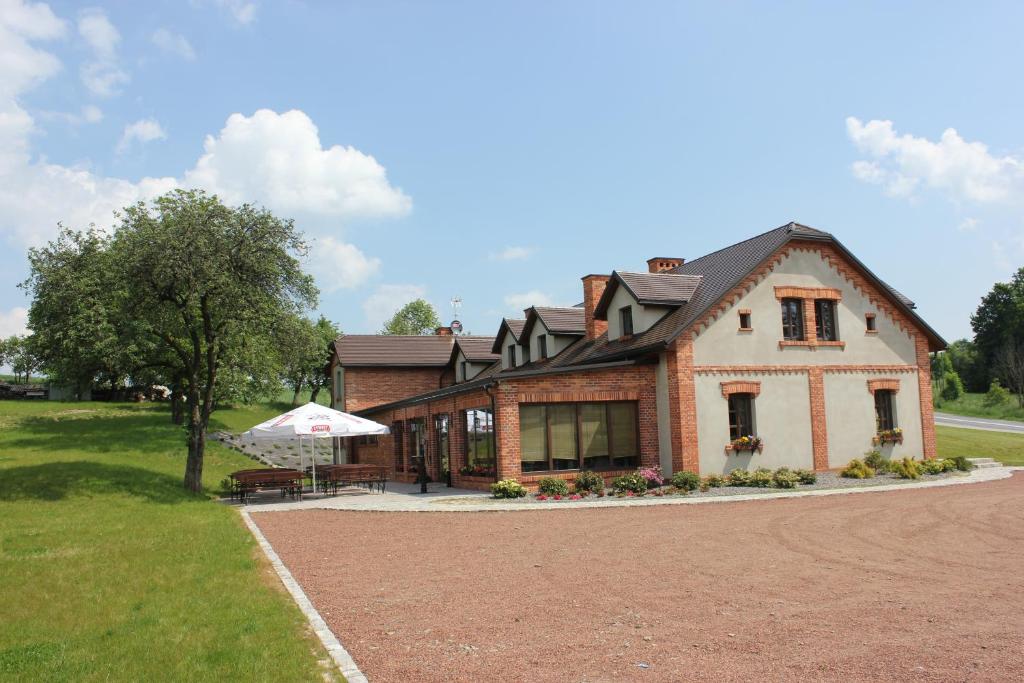 een huis met een picknicktafel ervoor bij Zajazd Ryszkówka in Bestwina