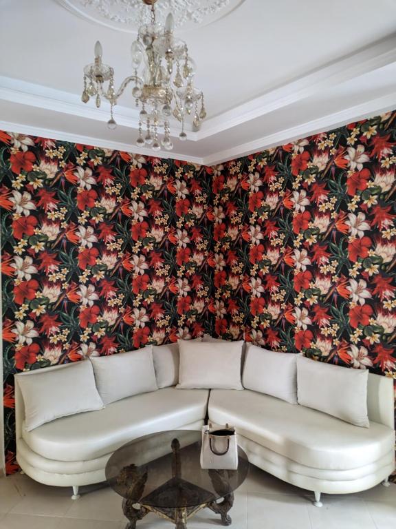 a living room with a couch and a floral wallpaper at Appartement Esmeralda in Tétouan