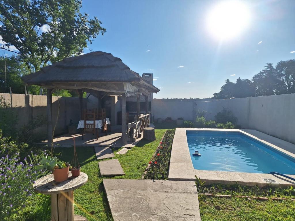 einen Hinterhof mit einem Pavillon und einem Pool in der Unterkunft La Casita de Areco in San Antonio de Areco