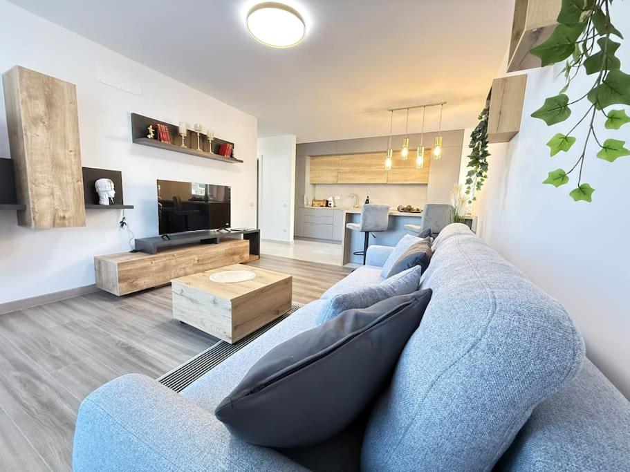 ブラショヴにあるJune's Urban Residenceの青いソファとテーブルのあるリビングルーム