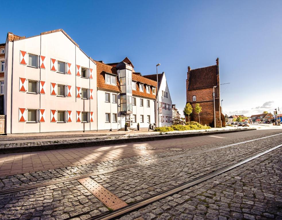 een lege straat met gebouwen en een geplaveide weg bij Hotel Am Alten Hafen in Wismar