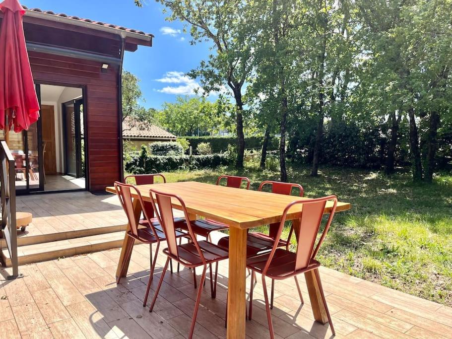 une table et des chaises en bois sur une terrasse dans l'établissement Maison proche de la Dune du Pyla 6pers, à La Teste-de-Buch