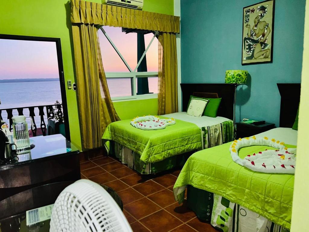 a bedroom with two beds and a window with the ocean at Ribiera del Lago Peten Itza in Flores