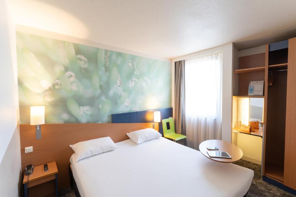 une chambre avec un grand lit blanc et une fenêtre dans l'établissement ibis Styles Angers Centre Gare, à Angers