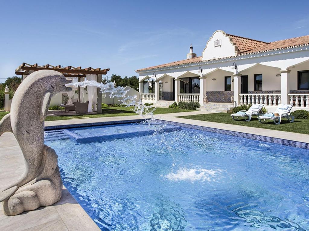 a house with a swimming pool with a fountain at Villa Flor de Lis - VIP Properties by Interhome in Paderne