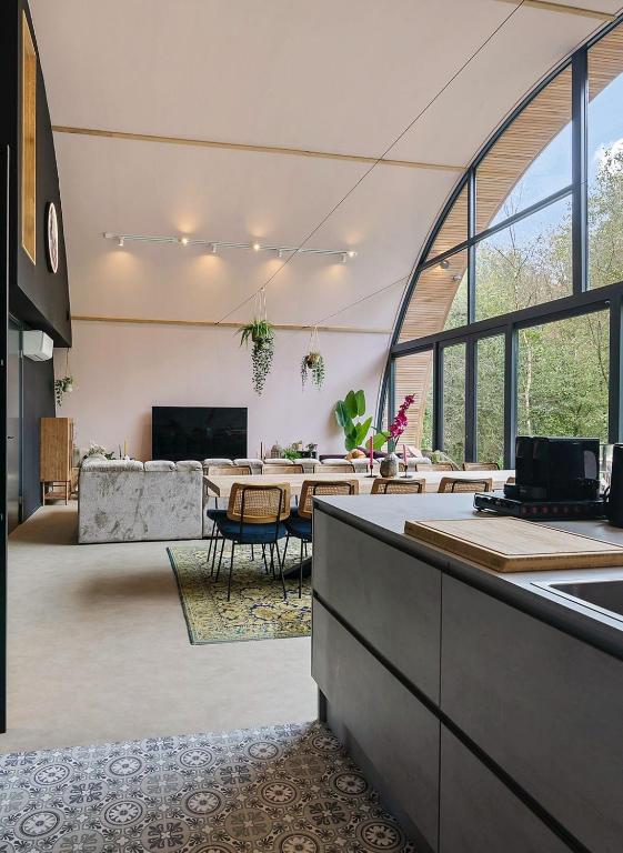a large living room with a table and a couch at Bosresort Maanzicht in Noordwolde