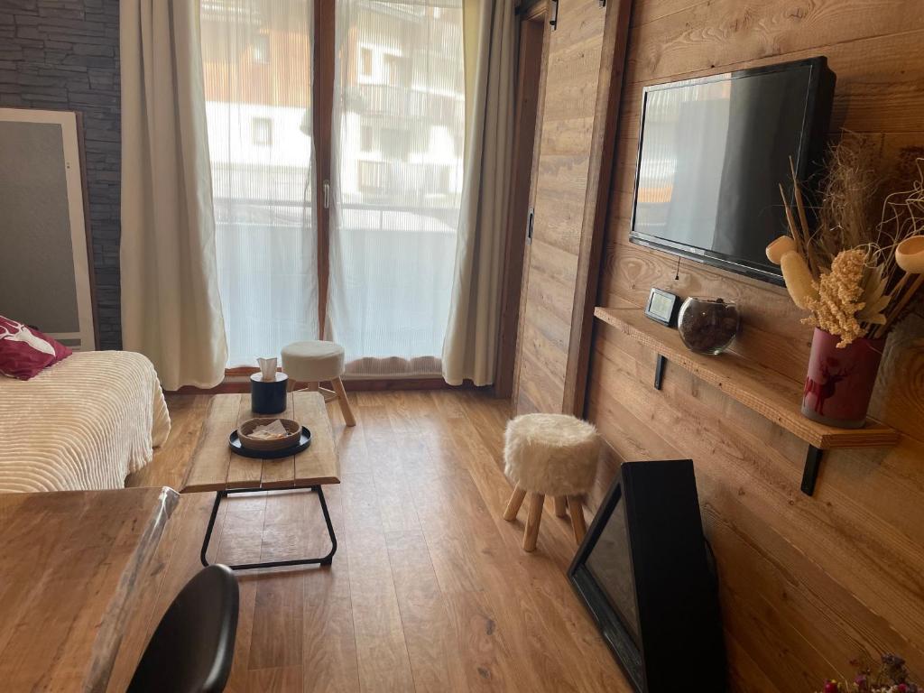un salon avec un canapé et une télévision dans l'établissement Appartement 6 pers les Orres 1800 - Piscine chauffée Sauna, aux Orres