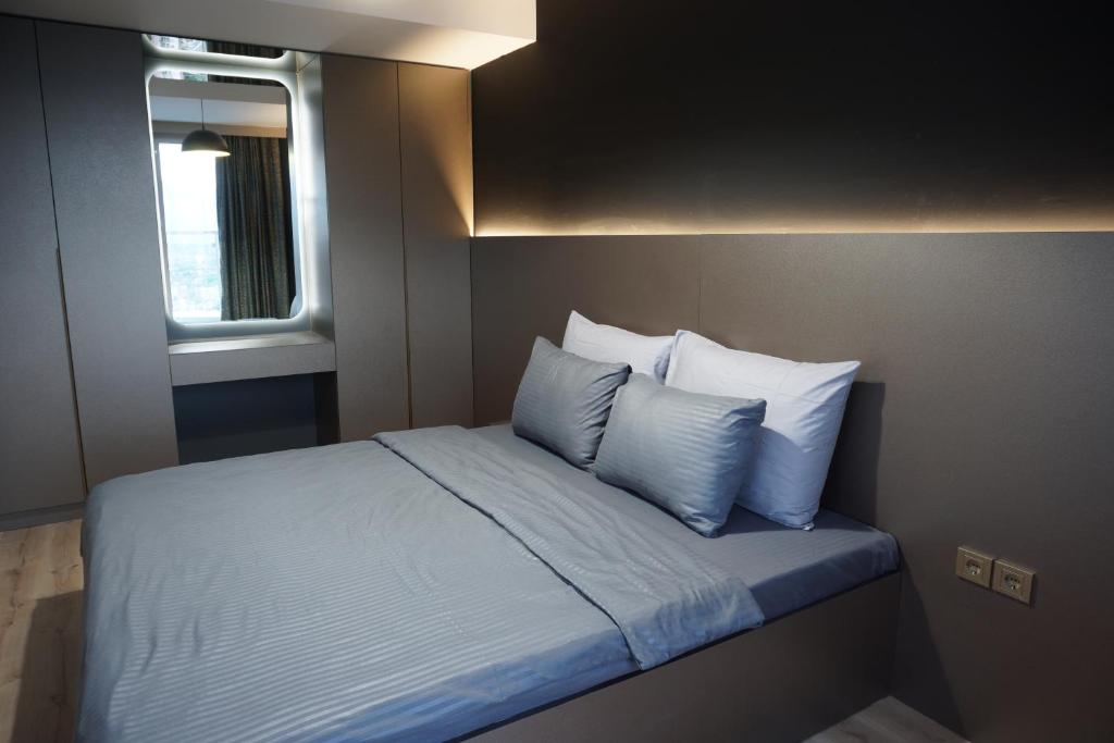 a bedroom with a bed with blue sheets and pillows at Royal Kate SPA included, 32nd floor in Skopje