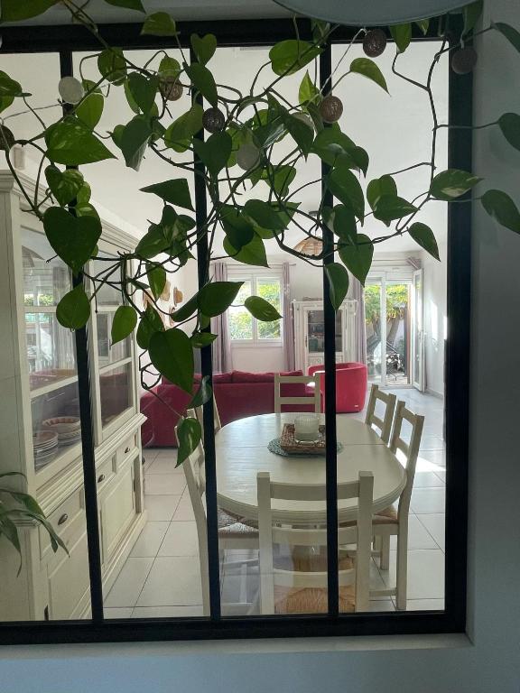 - une table et un arbre dans le salon dans l'établissement St Cyprien belle maison confortable ensoleillee avec jardin, à Saint-Cyprien