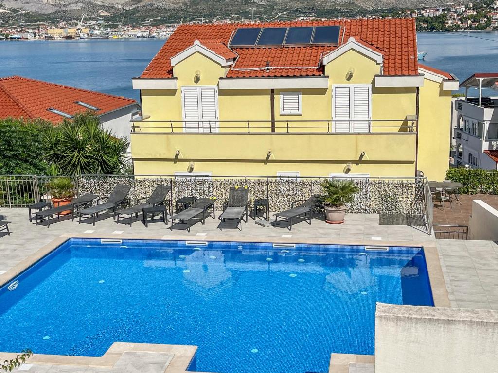 a swimming pool in front of a yellow building at Villa Luna in Trogir