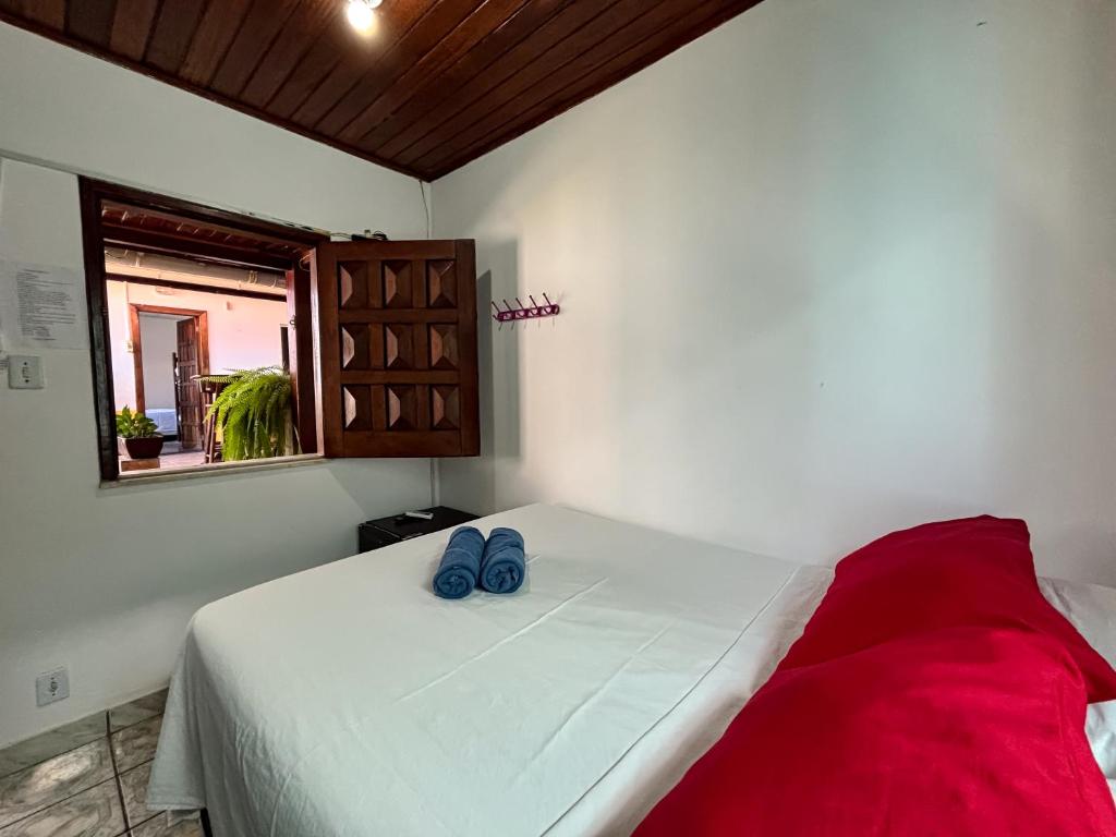 a bedroom with a bed with blue shoes on it at Pousada Beija flor in Morro de São Paulo