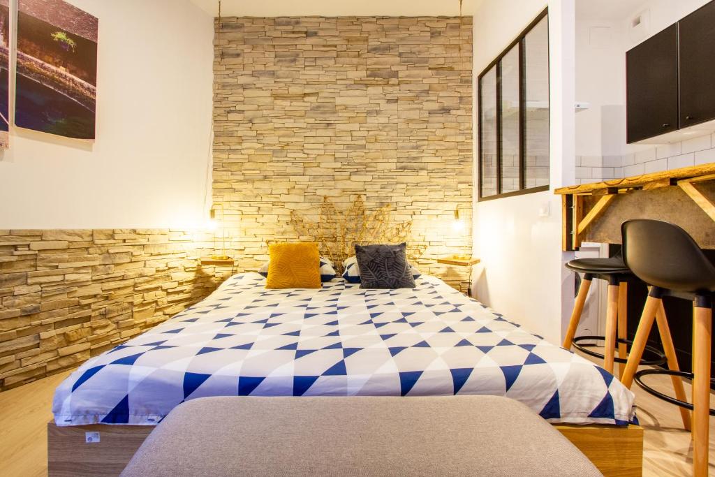 a bedroom with a blue and white checkered bed at Le Jardin des Bois - 5 min de la Fosse Dionne in Tonnerre