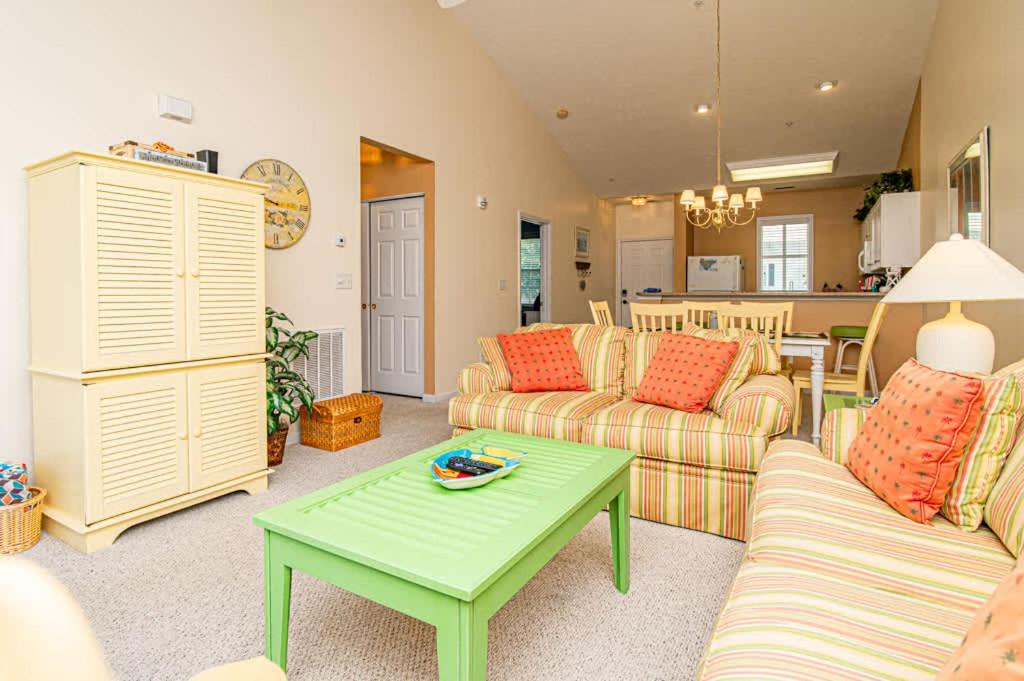 a living room with two couches and a green coffee table at Lakefront and 1 Block to Beach! Walk to Main St in Myrtle Beach