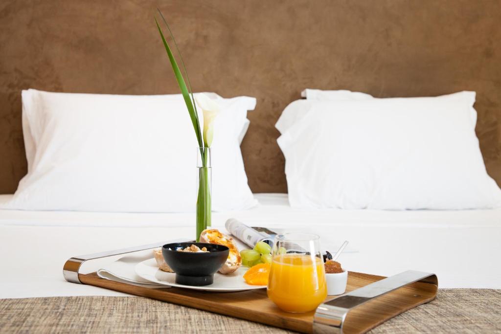 a tray with a plate of food on a bed at Daios Luxury Living in Thessaloniki