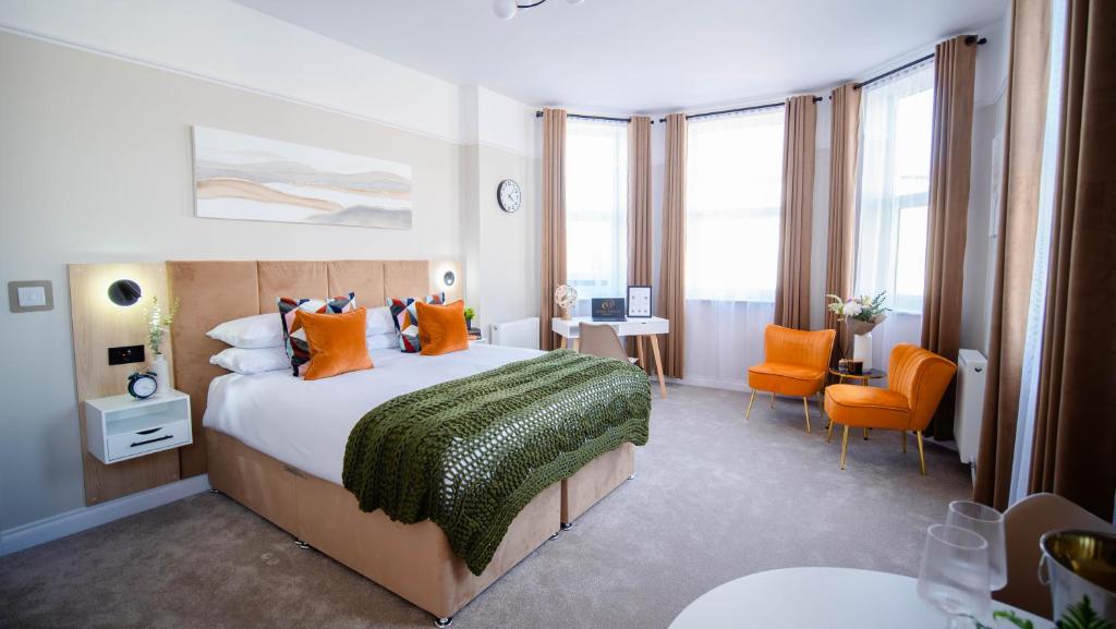 a bedroom with a large bed with orange pillows at Apart Hotel Rugby -Self Check In- in Rugby