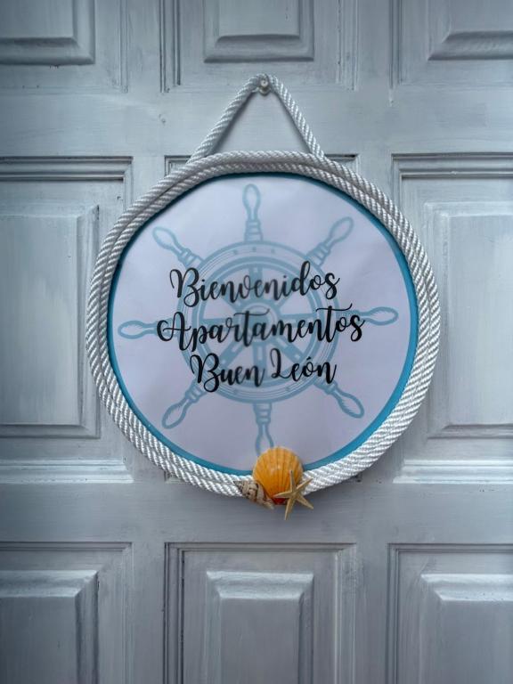 una señal colgando de una puerta con una calabaza naranja en Apartamentos Buen Leon, en Playa de Tasarte