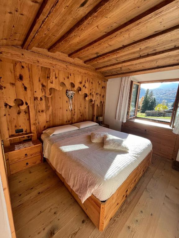 a bedroom with a bed in a room with a window at Daniela Apartment in Cortina dʼAmpezzo