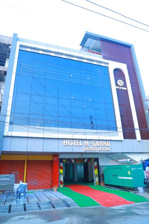 a building with a sign on the front of it at Hotel M Grand in Miriālgūda
