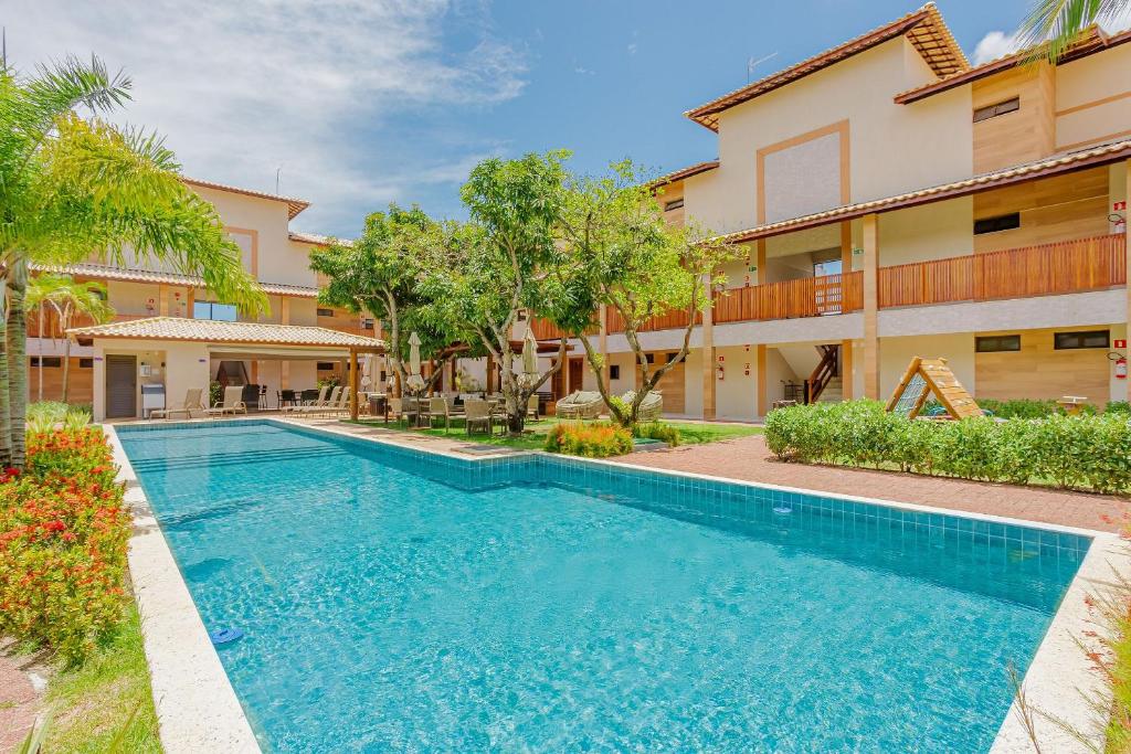 una piscina di fronte a un edificio di GB112 - Belo Apartamento Duplex 4 suítes - Guarajuba a Monte Gordo