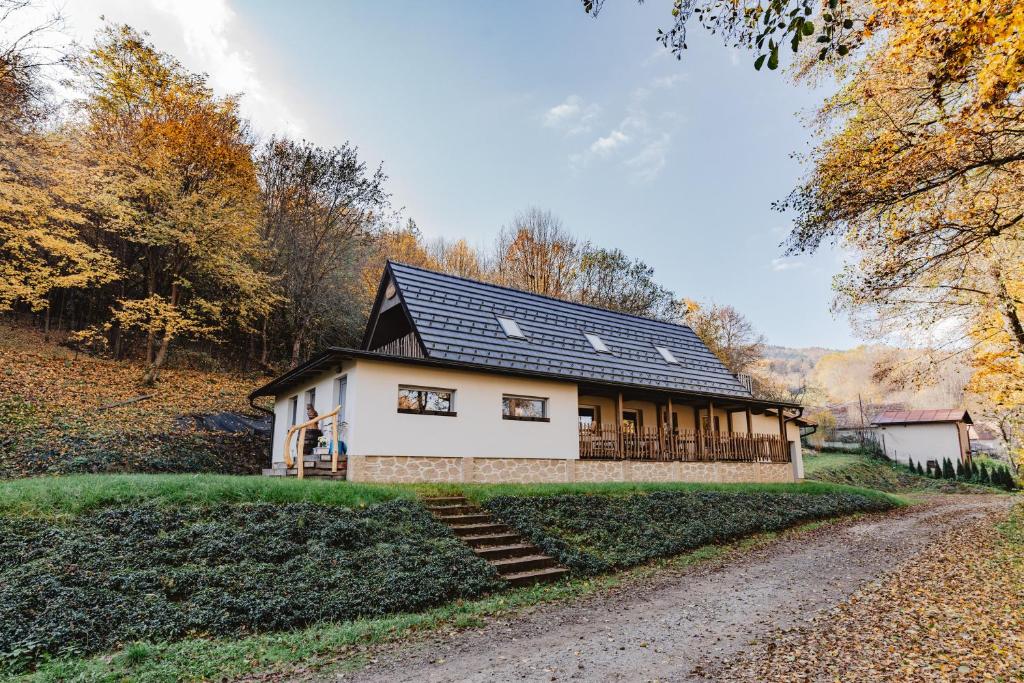 a house with a black roof on a gravel road at Chata Pekný les in Horné Hámre