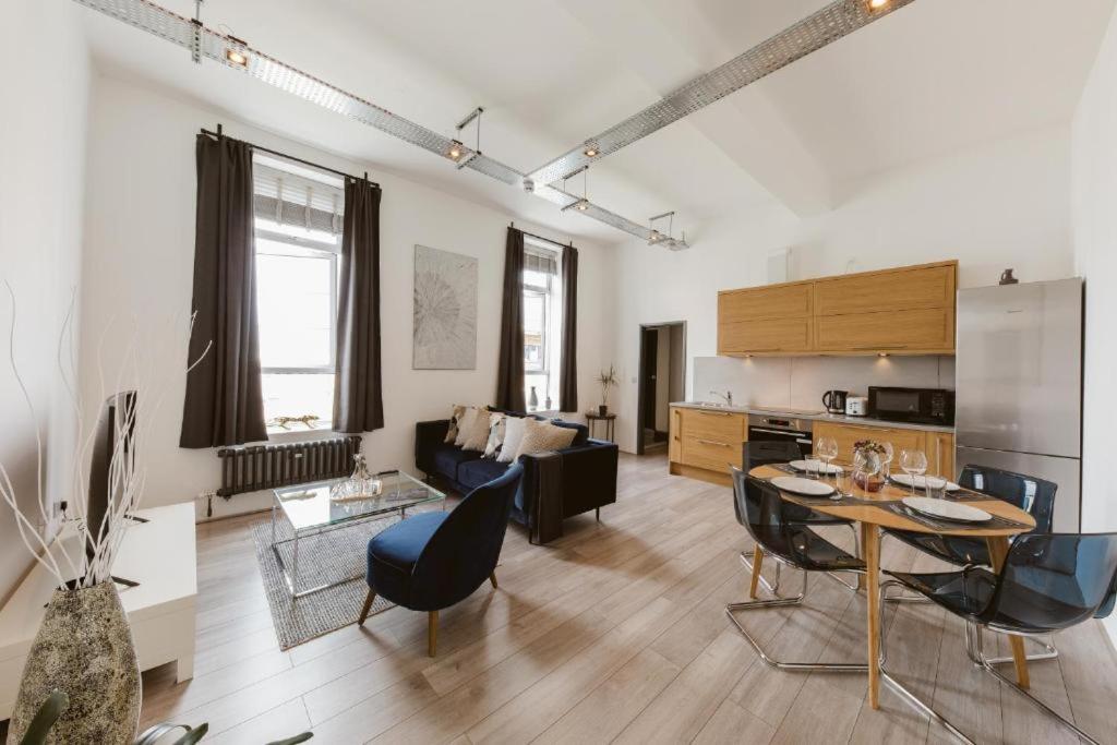 a living room with a table and a couch at Amazing warehouse conversion apartment in Chiswick in London