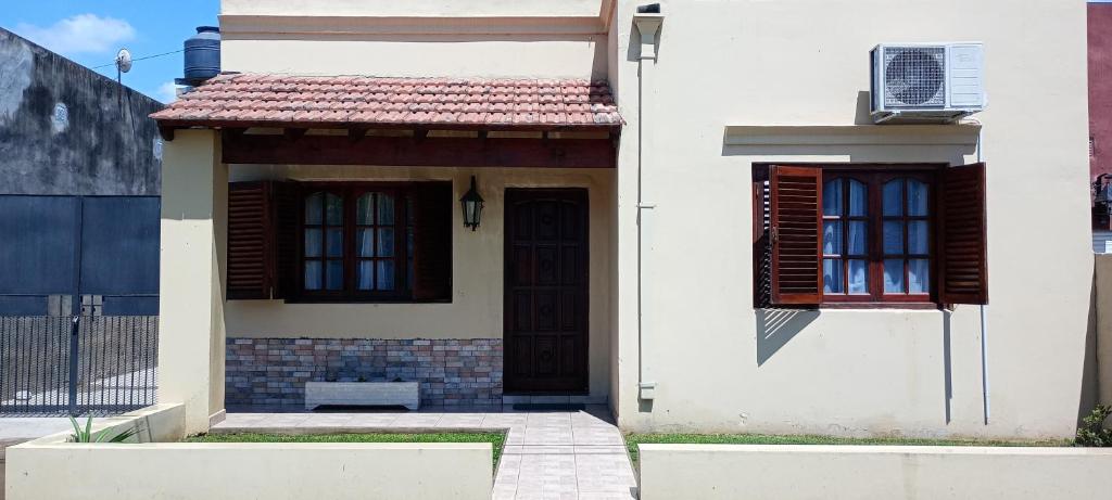 a white house with a door and windows at La Elvira in San Antonio de Areco