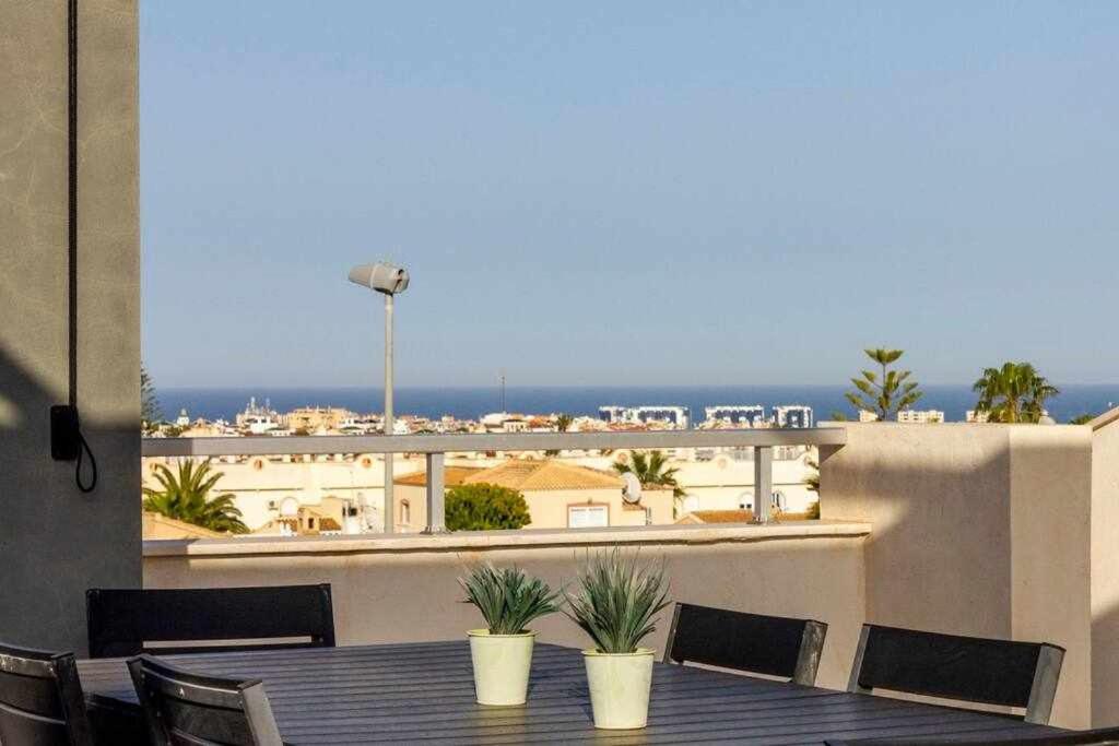 Una mesa y sillas en un balcón con vista. en Bungalow Pink Oasis - Winter by the Sea, en Alicante