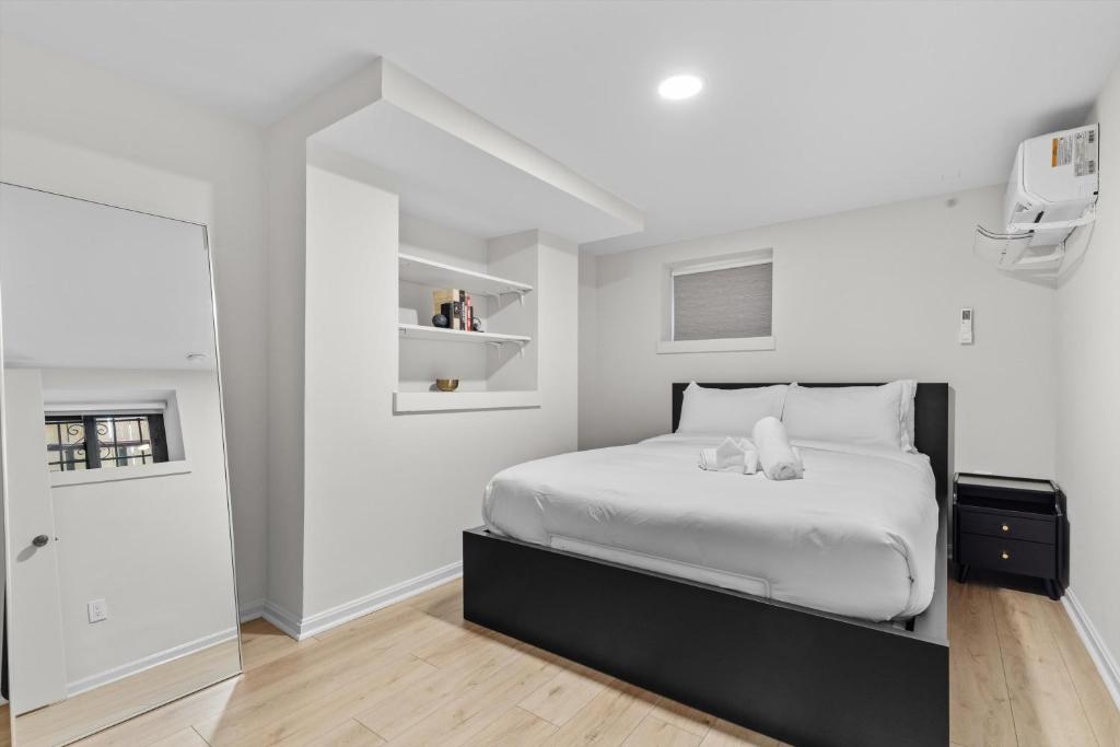 a white bedroom with a large bed and a door at Spacious NW Apt Steps to 14th Street Corridor in Washington, D.C.