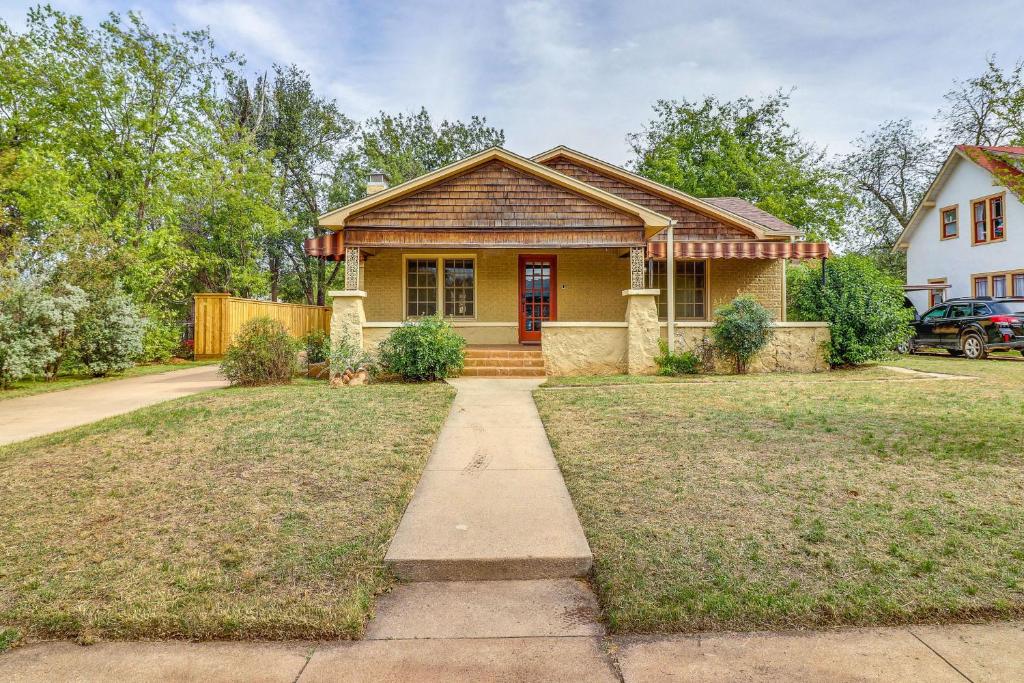 una casa amarilla con puerta roja en Centrally Located Abilene Abode 2 Mi to Downtown!, en Abilene