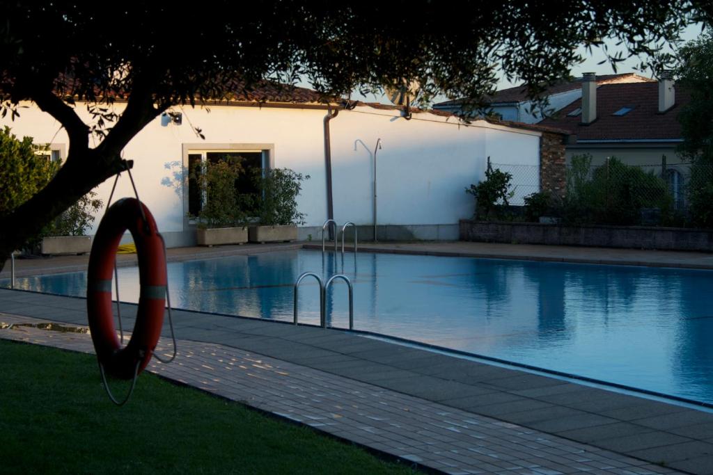 a swimming pool with a swing next to a house at Camping As Cancelas in Santiago de Compostela