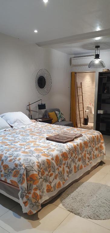 a bedroom with a large bed with a colorful blanket at Rose Maison Tahiti in Pirae