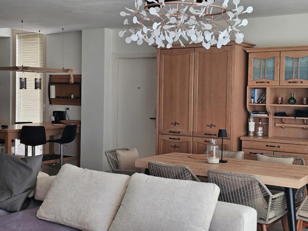 a living room with a table and a chandelier at Villa Champagne Green Coast Palase in Palasë