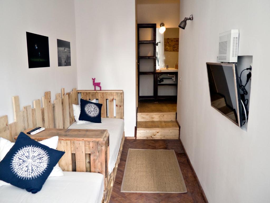 ブカレストにあるVictoria Poshtel Bucharestのベッド2台とテレビが備わる小さな客室です。