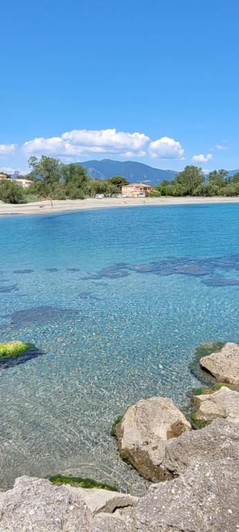 une grande étendue d'eau avec une plage en arrière-plan dans l'établissement Doalchaléda, à Linguizzetta