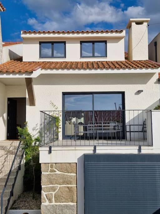 a house with a balcony with a table and chairs at Casa Francisca praia de Mindelo in Mindelo