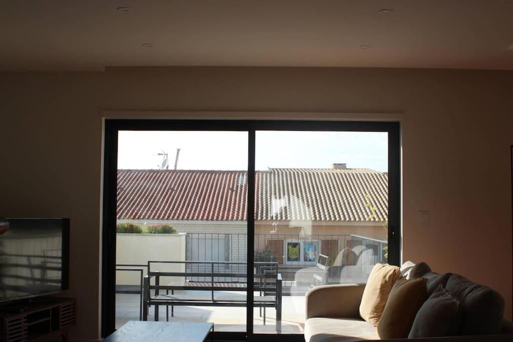 a living room with a couch and a large window at Casa Francisca praia de Mindelo in Mindelo