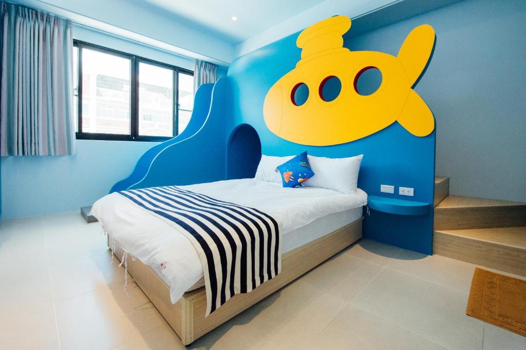 a bedroom with a bed with a yellow face on the wall at Yellow Kite Hostel in Tainan