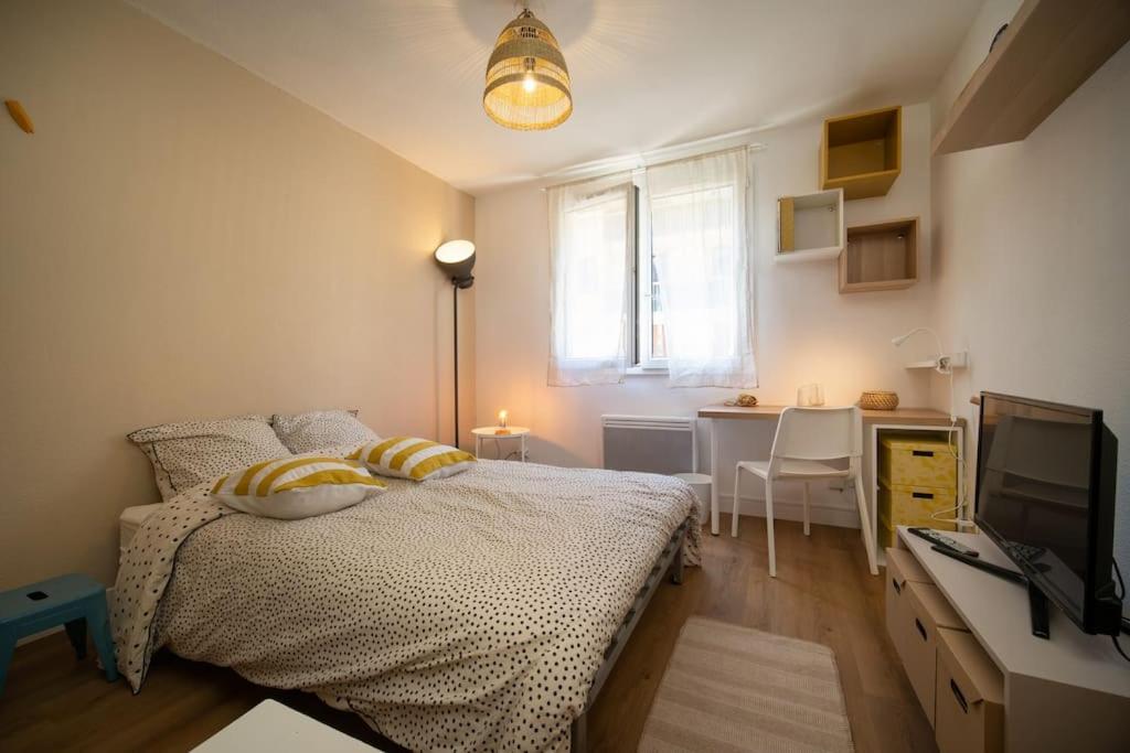 une chambre avec un lit et un bureau avec une télévision dans l'établissement Appartement tout equipe à coté de la Marseille Timone, à Marseille